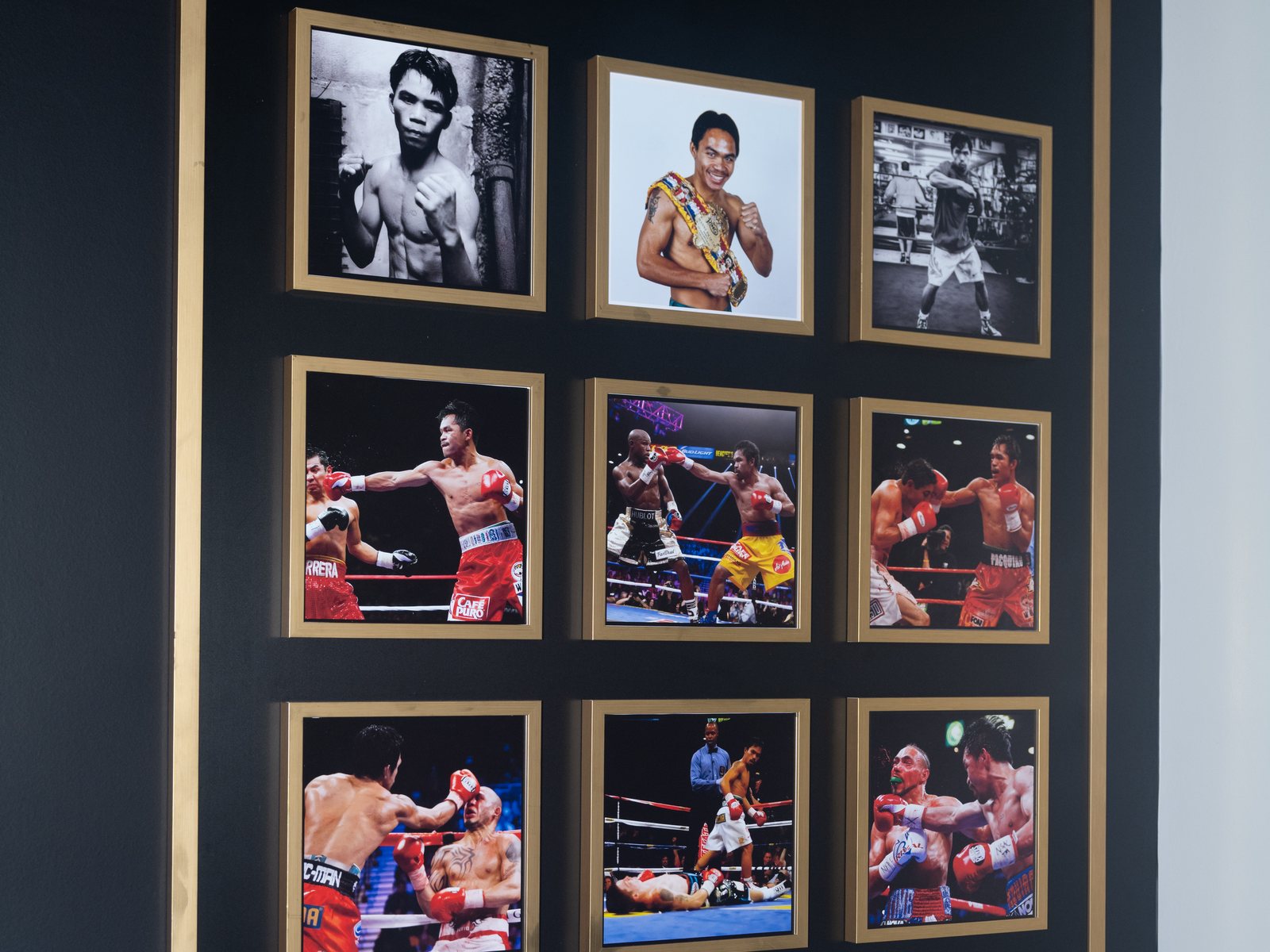 Framed photographs from Manny Pacquiao's career displayed on the
                    wall at Pacquiao Prime Boxing